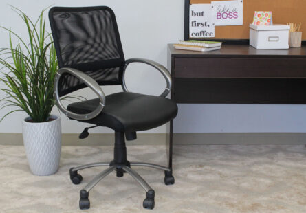 Mesh Back W/ Pewter Finish Task Chair in front of a desk with decor items and a potted plant beside it, indicating a modern workspace.