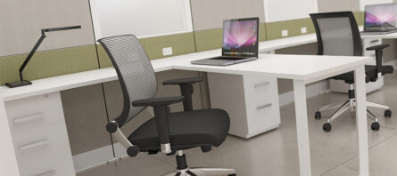 Modern office space featuring Interra Series desks with black office chairs and computers, set against green partition walls.