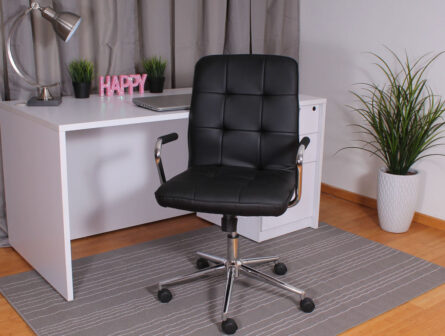 A modern home office setup with a white desk, Modern Office Chair w/Chrome Arms-Black, laptop, lamp, and a plant in a white pot.