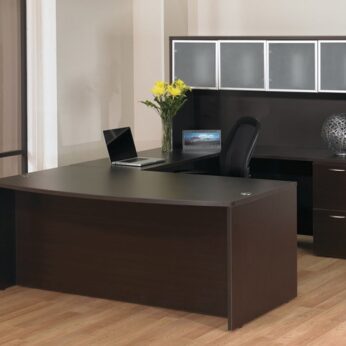 Modern office setup with a dark wooden desk, chair, laptop, and decorative items in a room with a large window and light flooring.