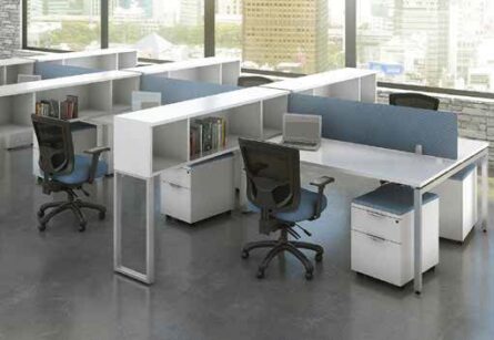 Modern office space with several Elements Series Desks with floor supported Hutch, each featuring a desk, chairs, and shelves, set against large windows overlooking a cityscape.