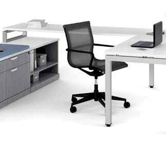 Modern office setup with an Elements Series U-shaped desk without hutch, rolling chair, desktop computer, and a potted plant on a cabinet.