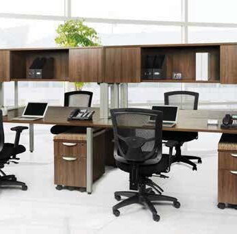 Modern office space featuring a cluster of Elements desks with overhead #3 (Single Unit) in black office chairs, laptops, and partition panels.