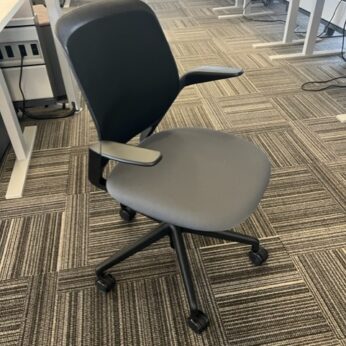 A chair with arms and wheels on the floor.