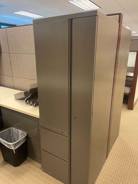 Tall gray metal cabinet in office setting.