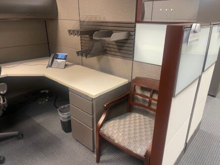 Office cubicle with desk and chair.