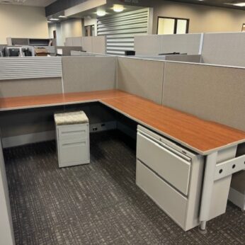 Modern office cubicle with desk and storage.