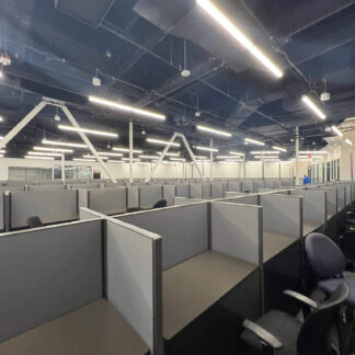 Empty office cubicles with overhead lighting.